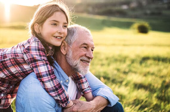 Girl hugging grandfather who is participating in clinical trial.