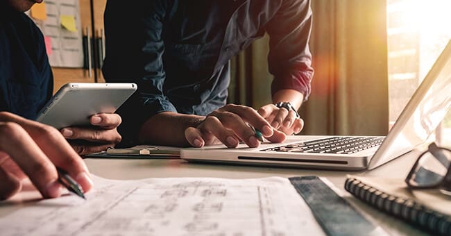 Marketing Agency meeting showing technical drawings and a laptop