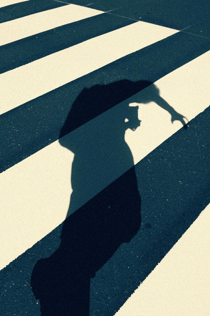 Photo of a person's shadow on a crosswalk as a metaphor for breaking rules in when writing marketing copy/text.