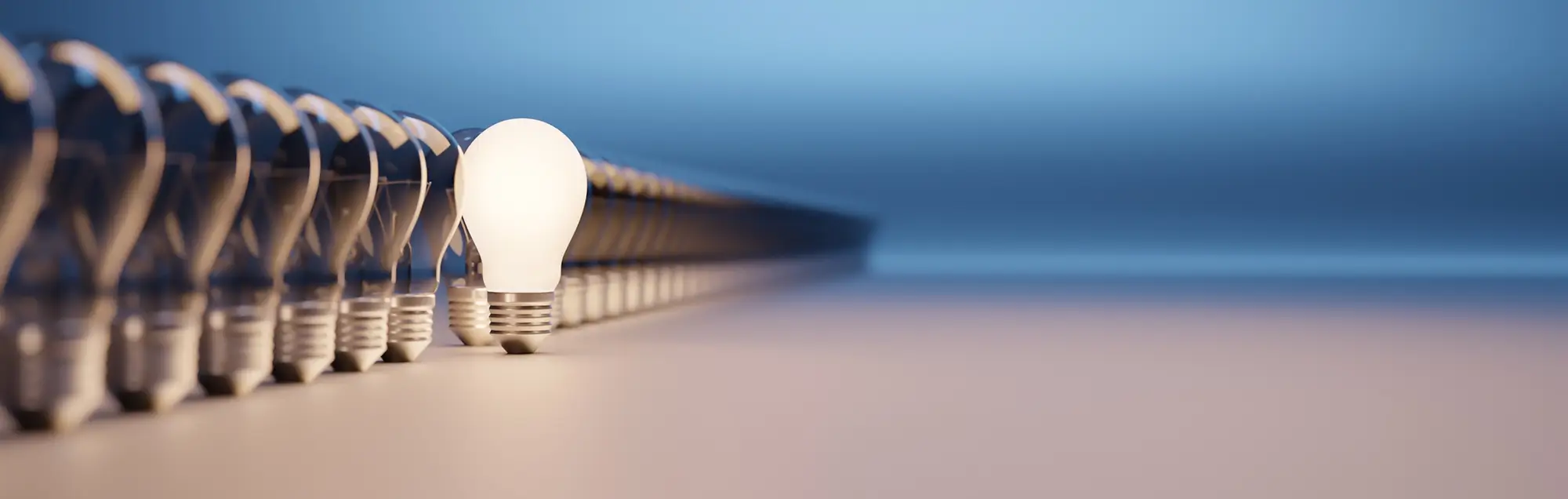 One bright light bulb standing out from a line of other dim light bulbs